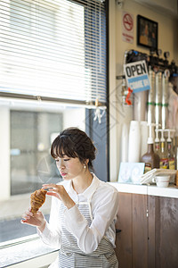 咖啡馆女休息吃着烤面包的店员图片