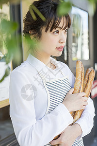 抱着法式面包的年轻女性图片