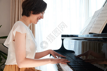 女性在家中弹钢琴图片