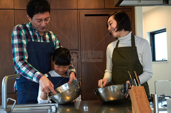 父母和孩子们享受烹饪图片