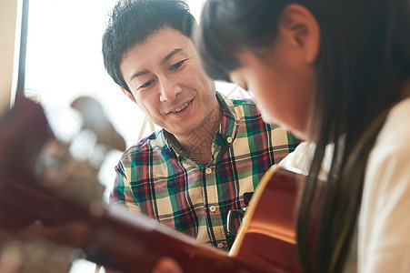 父女在家学习弹吉他图片