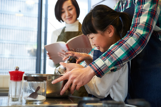 父母和孩子们享受烹饪图片