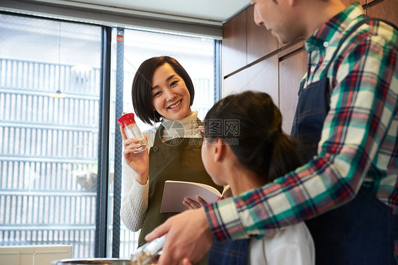 父母和孩子们享受烹饪图片