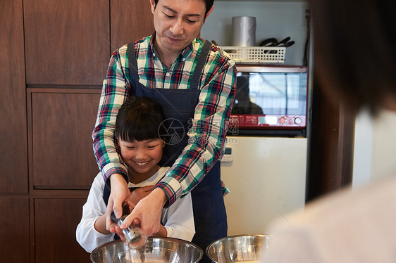 父母和孩子们享受烹饪图片