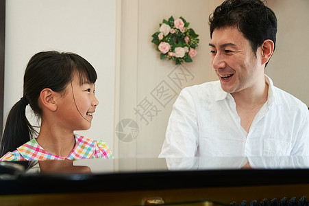 小女孩在家里学习钢琴课图片