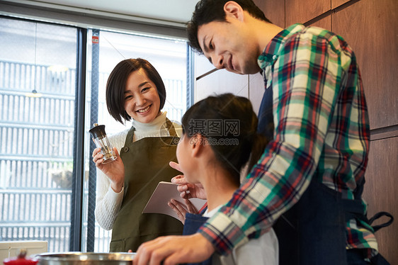 父母和孩子们享受烹饪图片