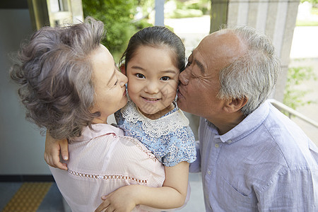 爷爷奶奶在亲吻孙女的脸颊图片
