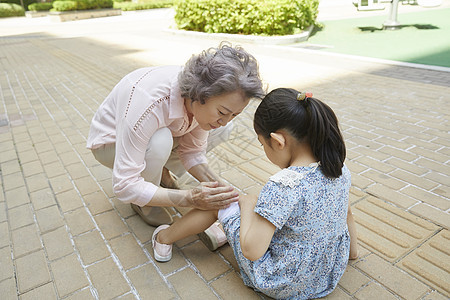 奶奶安抚摔倒的小女孩图片