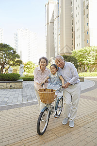 扶着孙女骑着的退休老年夫妇图片