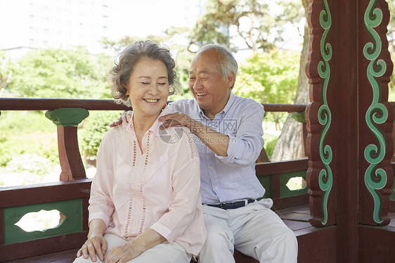 亭子里帮妻子按摩肩颈的丈夫图片