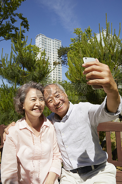 拿着手机自拍微笑的老夫妇图片