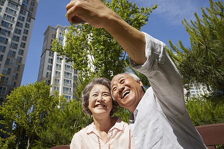 拿着手机自拍微笑的老年夫妇图片