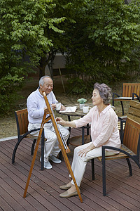 花园里绘画喝茶的退休老年夫妇图片