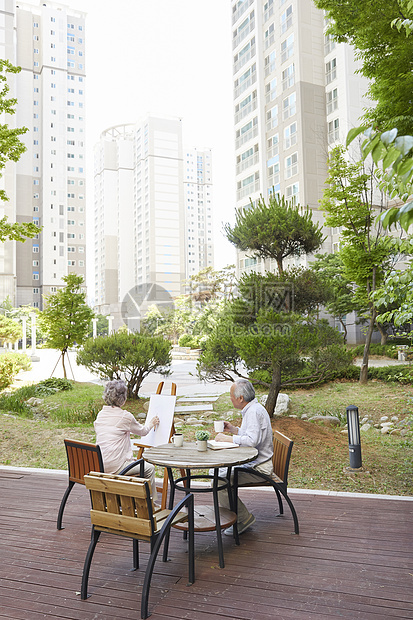 花园里绘画喝茶的退休老年夫妇图片