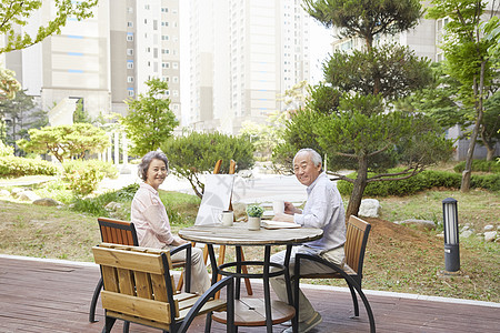 花园里绘画喝茶的退休老年夫妇图片