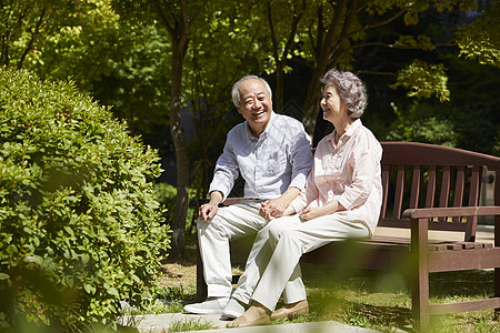 公园里坐在长凳上休息的老夫妇图片