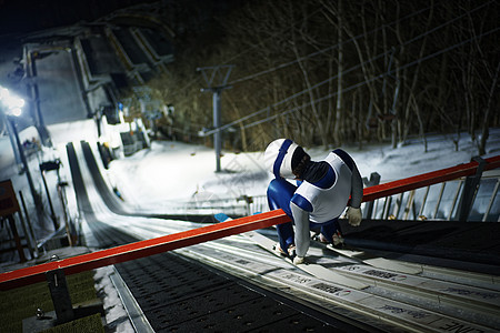 夜晚滑雪场大跳台训练的运动员图片