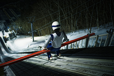 夜晚滑雪场大跳台训练的运动员图片