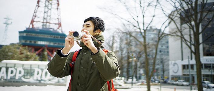 观光旅游拿着相机拍照的青年男性图片