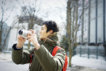 观光旅游拿着相机拍照的年轻男性图片