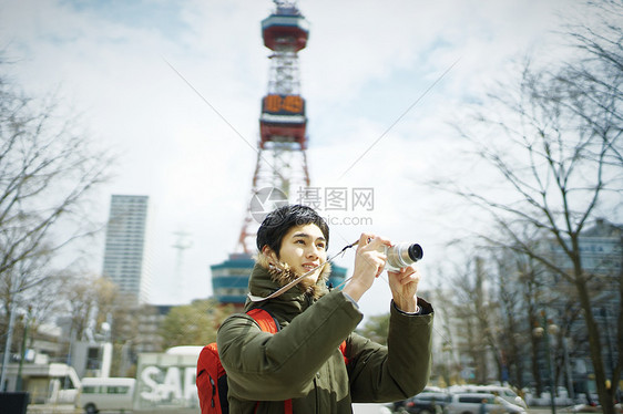 观光旅游拿着相机拍照的年轻人图片