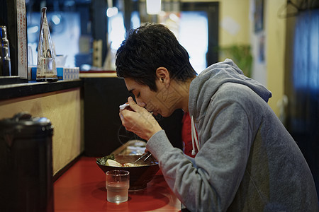 餐馆里吃着拉面的青年男性图片