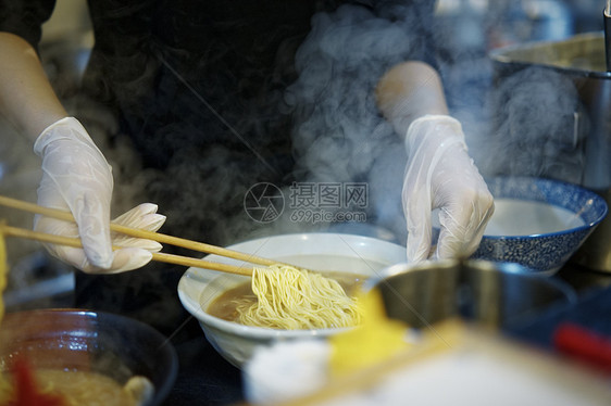 拉面馆翻动面条的后厨图片