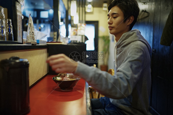 独自坐在拉面店吧台座位的男士图片