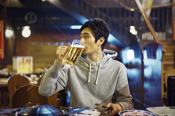 餐厅里喝着大杯啤酒的成年男性图片