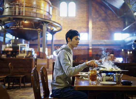 餐厅里独自烤肉的青年男性图片