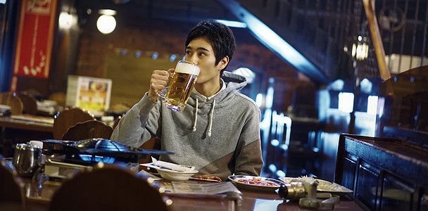喝着大杯啤酒的青年男性图片