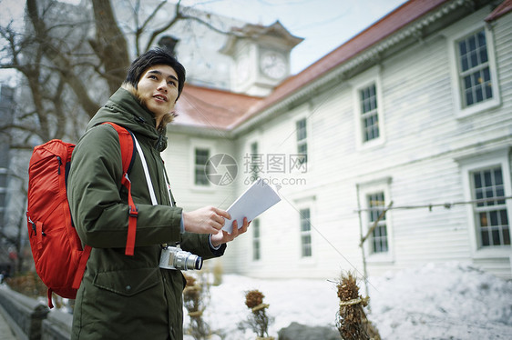 拿着手册独自旅游观光的青年男性图片