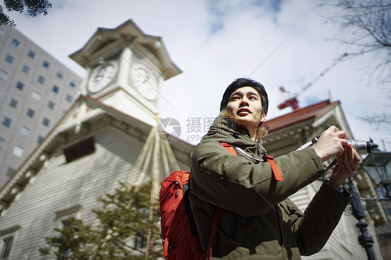 拿着相机独自旅游观光的青年男性图片