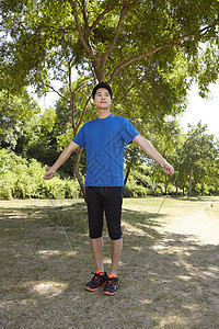 公园里跳绳运动青年背景图片