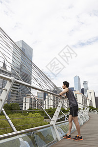 靠在栏杆上休息的男青年图片