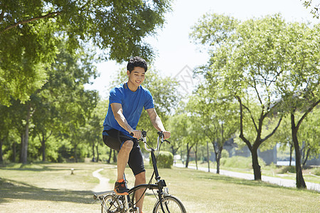 公园里骑着自行车的男青年图片