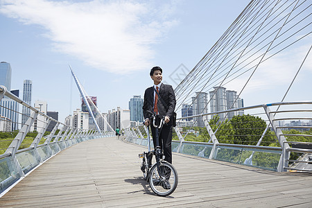 大桥上推着自行车的成年男性图片