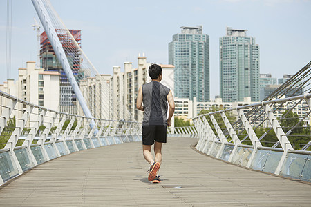 穿着运动服跑步运动的青年男性背影图片