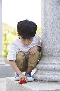 石柱旁的小男孩图片