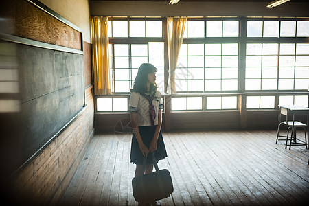 建筑剪影教室里拿着包的高中女孩背景