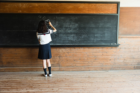 在黑板上涂鸦的高中女孩图片