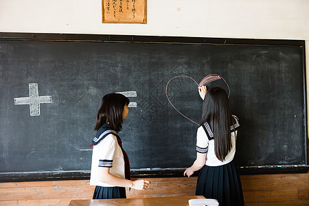 在黑板上写字画画的高中女孩图片