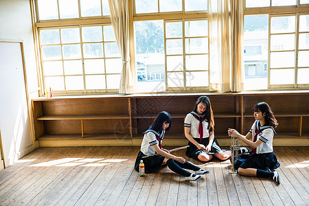 坐在地板上休息的女高中生图片
