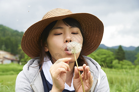 农业妇女开心的吹着蒲公英图片