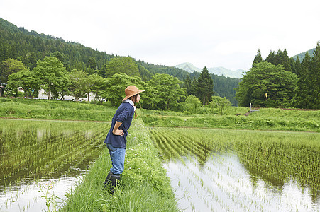 种植水稻后在田里休息的年轻农民图片