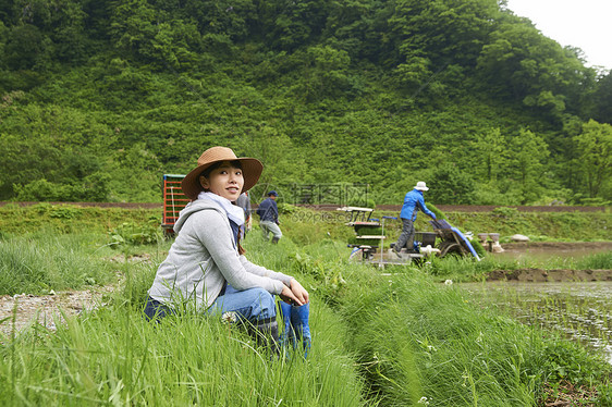 种植水稻后在田里休息的年轻农民图片