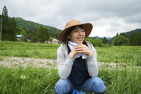 种植水稻后在田里休息的年轻农民图片