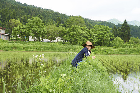 种植水稻后在田里休息的年轻农民图片