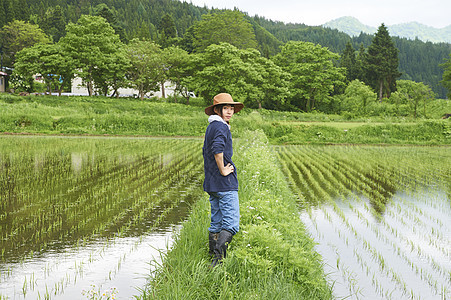 种植水稻后在田里休息的年轻农民图片