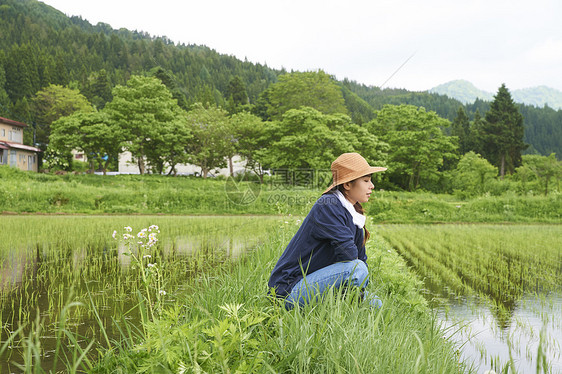 种植水稻后在田里休息的年轻农民图片